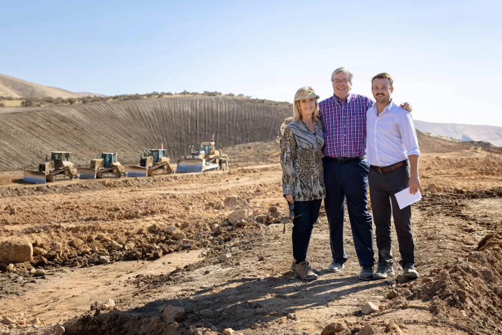 Three people standing on a land development site